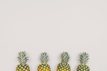 four pineapples on white background